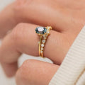 Gold plated floral women's ring with inlaid green zircon stones on a white background.