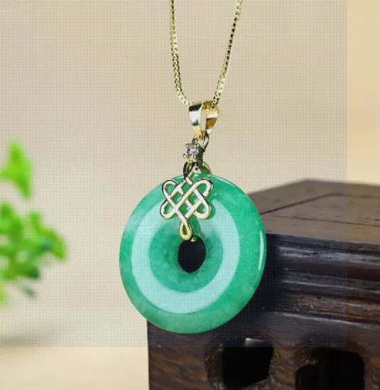 Dry green jade coin buckle pendant 25mm diameter on a light background