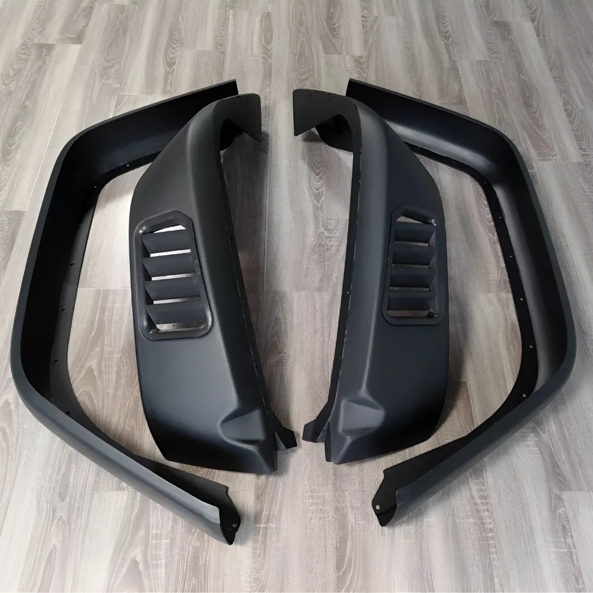 Set of 4 black plastic car wheel brow trims for universal automotive use on a white background