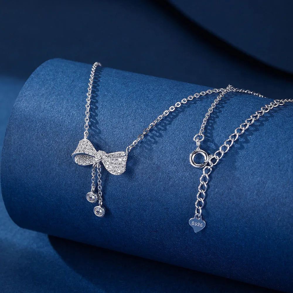 S925 sterling silver necklace with bow pendant on an O-ring chain, shown at clavicle length.