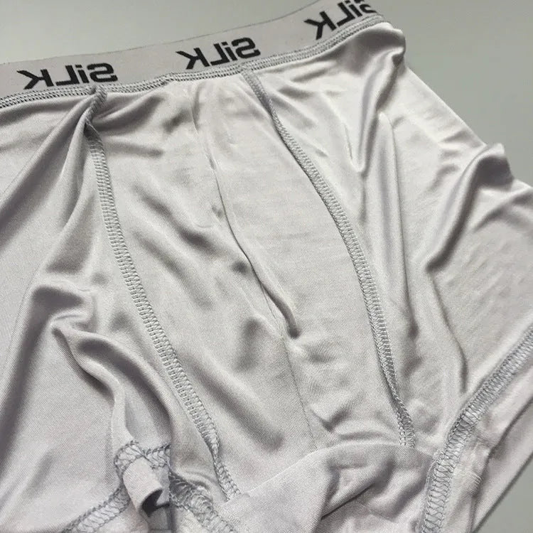 Men's loose navy blue silk shorts with a mid-waist design on a neutral background