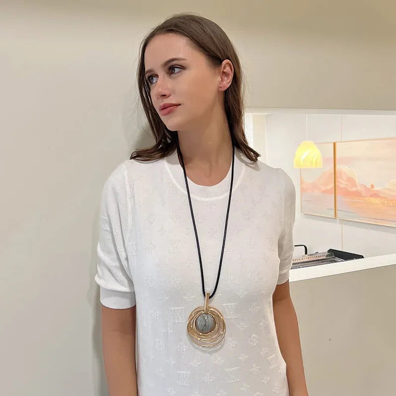 Gold geometric pendant sweater chain necklace with snakeskin texture rope on model