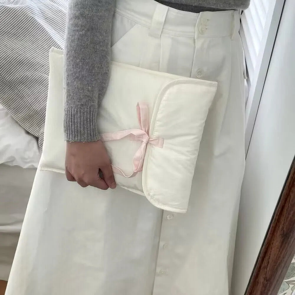 Black and white quilted women's laptop bag with striped pattern and a ballet-style bow.