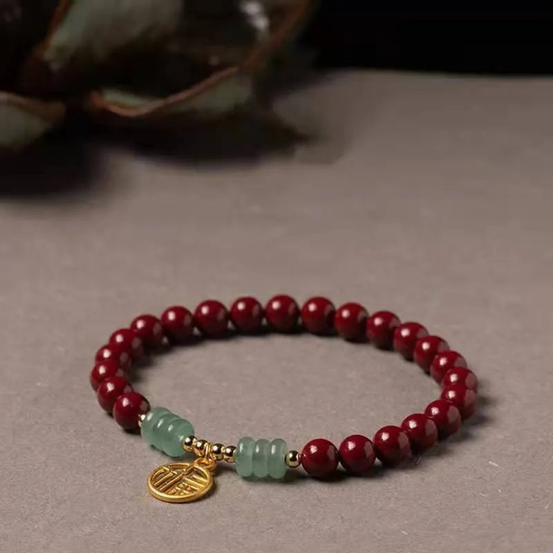Close-up of a handcrafted wave-pattern bracelet made from red cinnabar and copper beads.