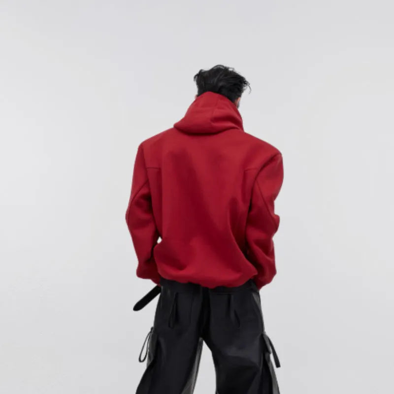 Men's loose grey hooded sweater with metallic graphic print and structured shoulder pads on a hanger.