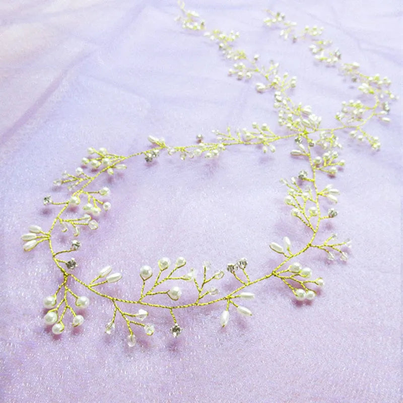 Close-up of a silver bride's hair band with pearls and crystals on a wired base.