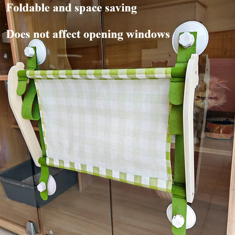 Pink foldable wooden cat window bed with suction cups attached to a glass window