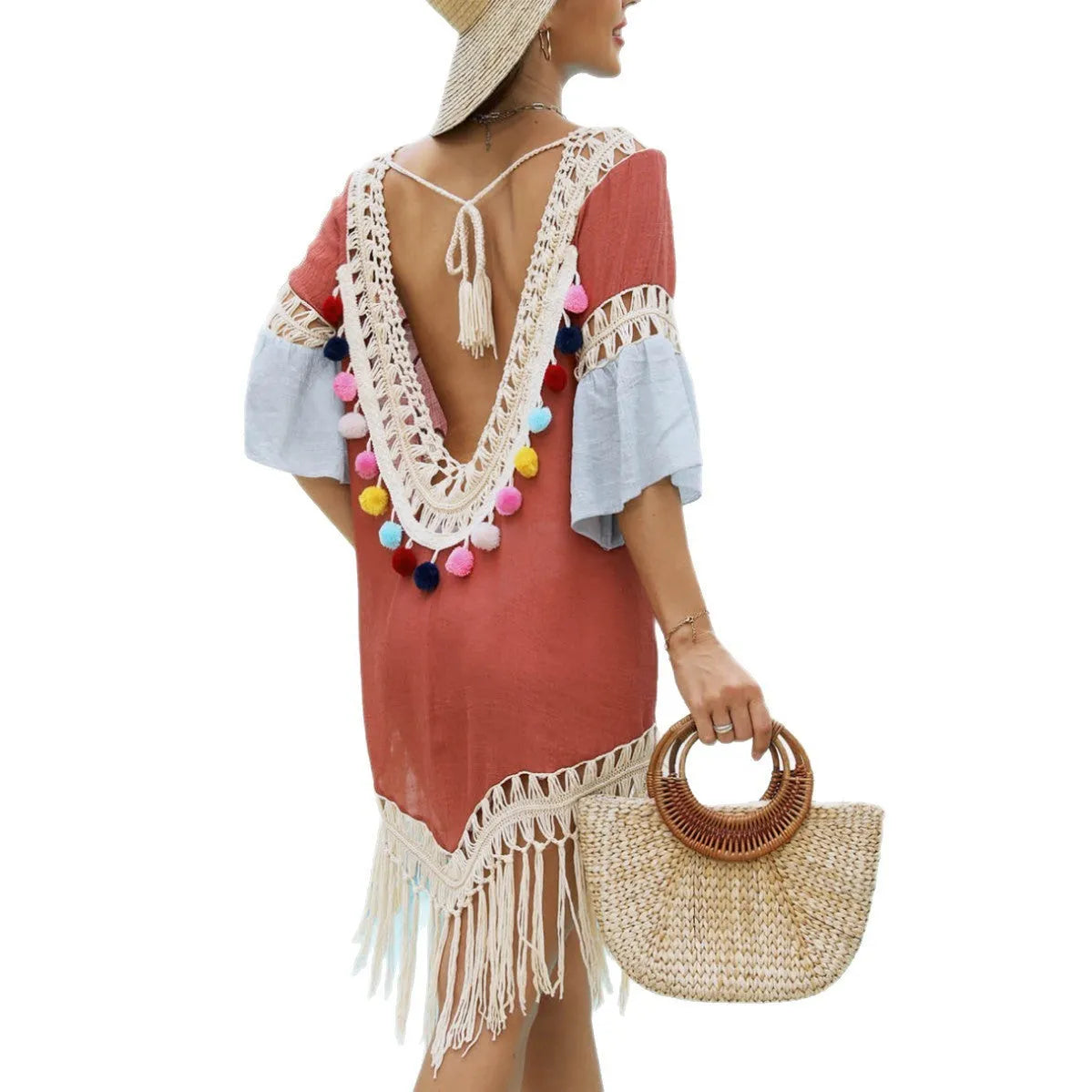 Orange floral pattern beach overskirt with hand crochet detail and tassels, laid flat.