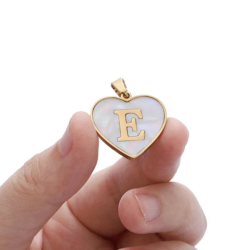 Gold-plated heart necklace with white shell pendant and initial personalisation on a stainless steel chain.