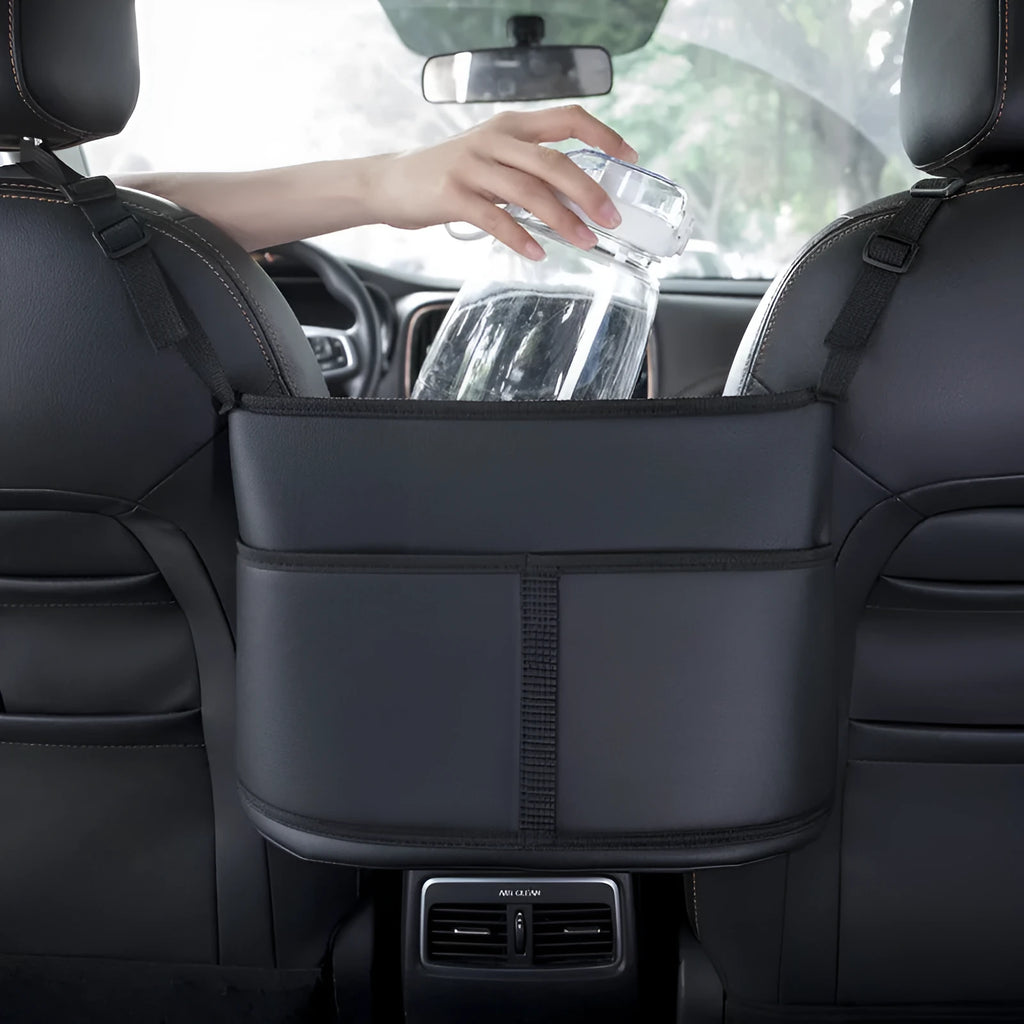 Black leather car seat gap storage organiser bag with carbon fibre pattern, shown between car seats.