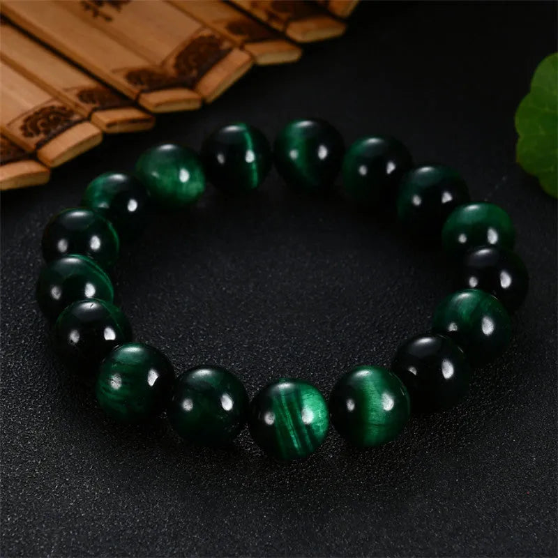 Green Tiger Eye stone bracelet with polished geometry beads on a wrist.