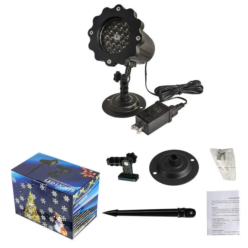 LED Christmas snowflake laser light projector IP65 waterproof with white snowflakes projecting onto a garden wall at night
