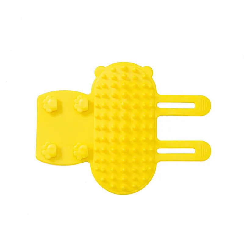 Silicone cat grooming massage comb with adjustable strap mounted on furniture leg