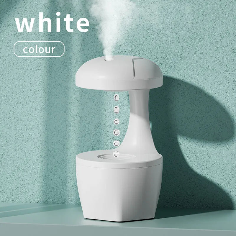 White portable 800ml anti gravity USB cool mist aromatherapy humidifier on a bedside table with water droplet effect visible