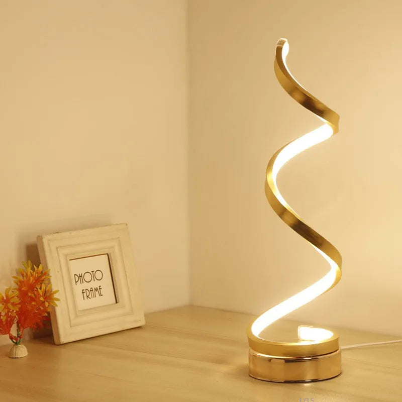 Black and white minimalist LED table lamp with aluminium shade on a desk.