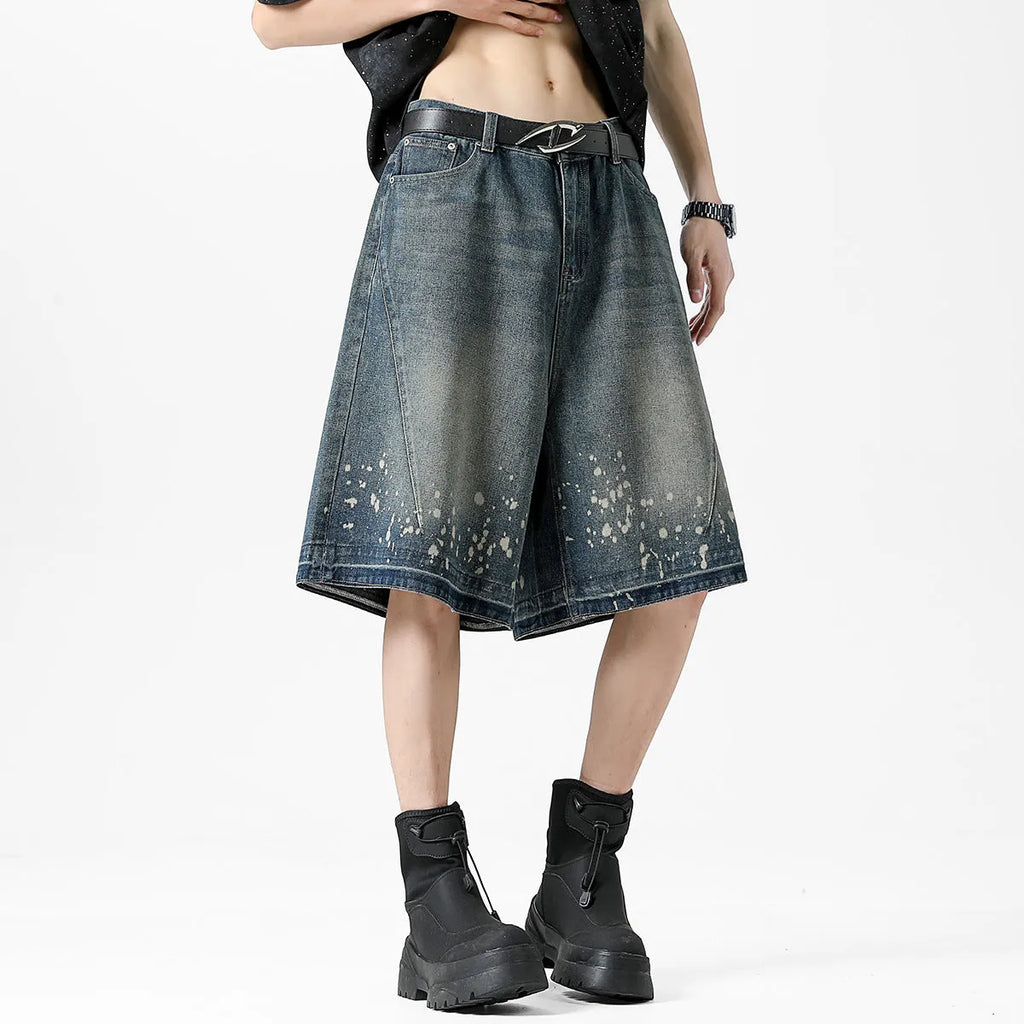 Retro blue washed denim shorts for men with a splash ink pattern and ripped detailing on the legs.