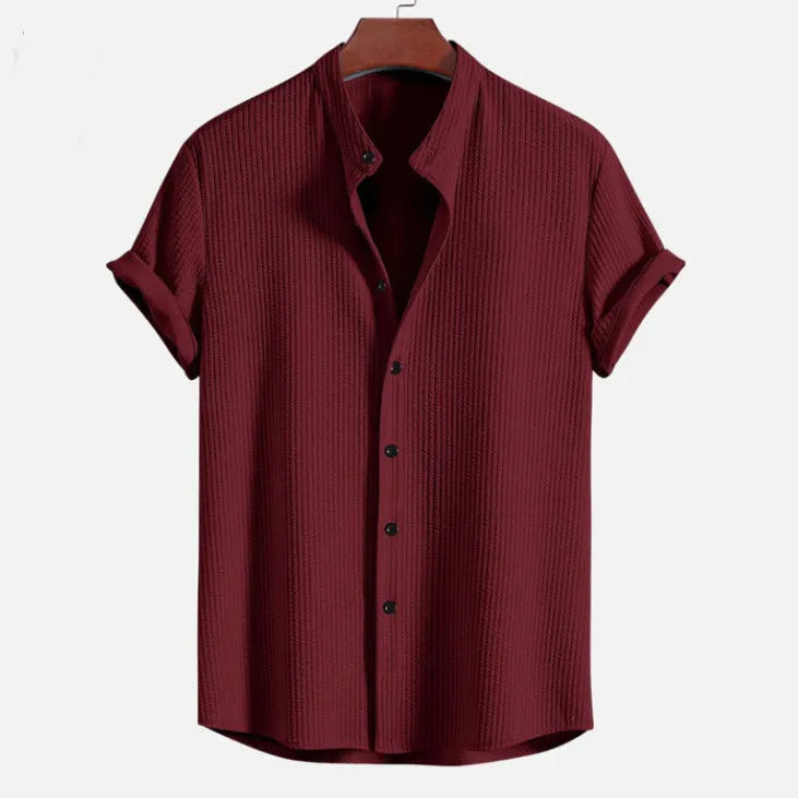 Men's loose fit short sleeve casual shirt in light blue, hanging on a plain background.