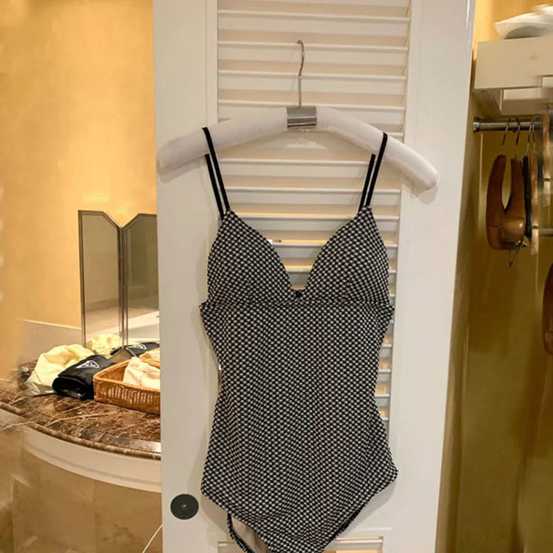 Polyester one-piece swimsuit for hot spring use in black or blue with belly cover design