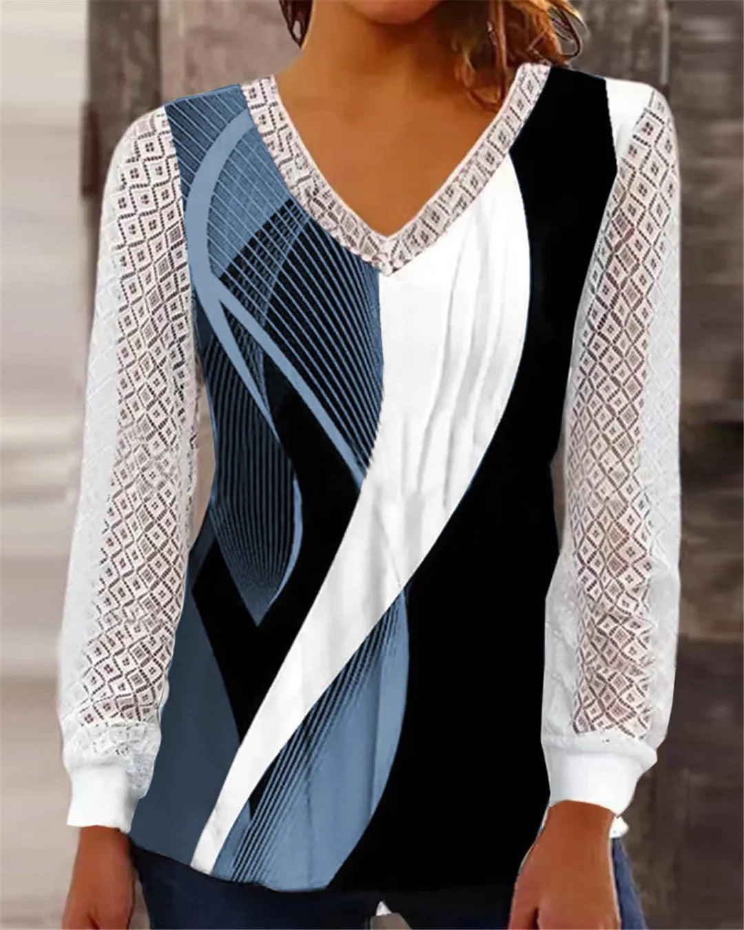 Purple loose V-neck top with lace print detail and long sleeves on a hanger.