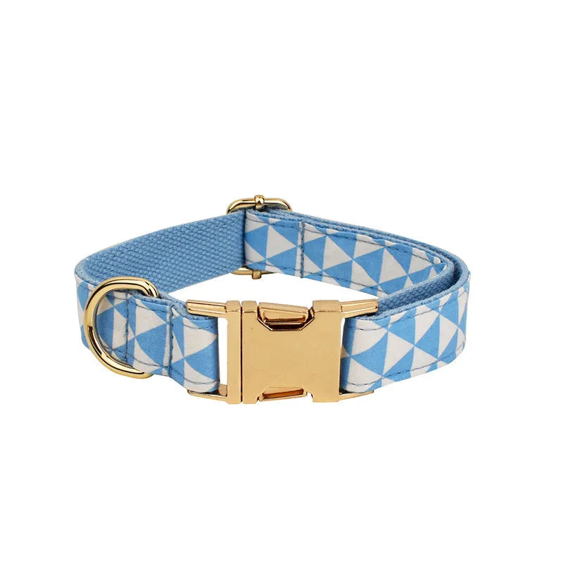 Blue cloth dog vest set with matching collar, lead, and decorative bow on a triangular ring.