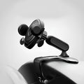 Black multifunctional car phone holder clipped onto a car sun visor, holding a smartphone.