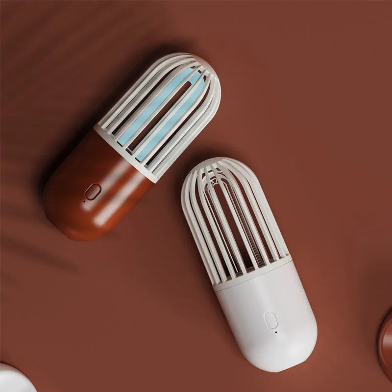 Portable capsule-shaped UVC disinfection lamp in black, showing compact size.