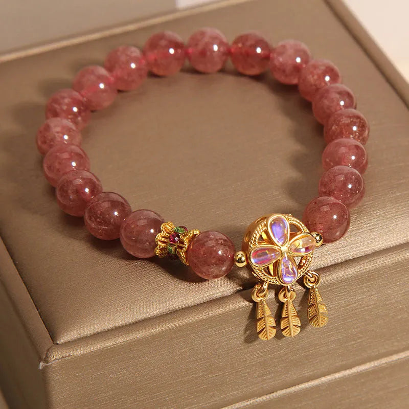 Natural strawberry quartz bracelet for women with a four-leaf dream catcher ball pendant on an elastic cord.