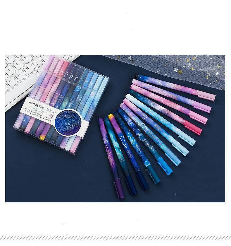 Twelve constellation ballpoint pens with zodiac designs on a light background