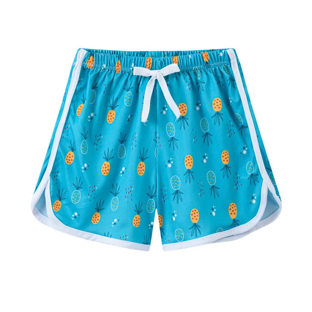 Children's polyester holiday shorts in multiple colours and patterns including stripes, leopard print, and pineapple design.