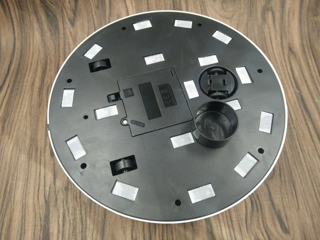 AC robot vacuum cleaner automatic sweeping machine in black or white on a hardwood floor.