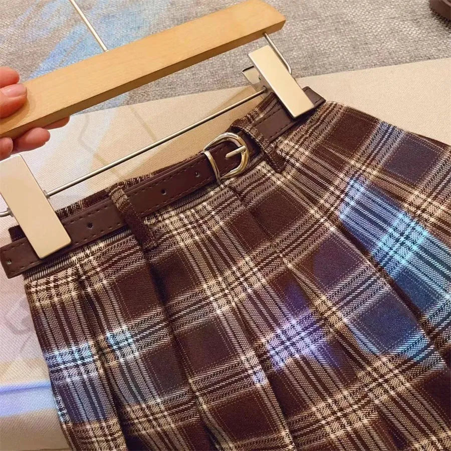 Girls red and black plaid pleated A-line skirt on a hanger.