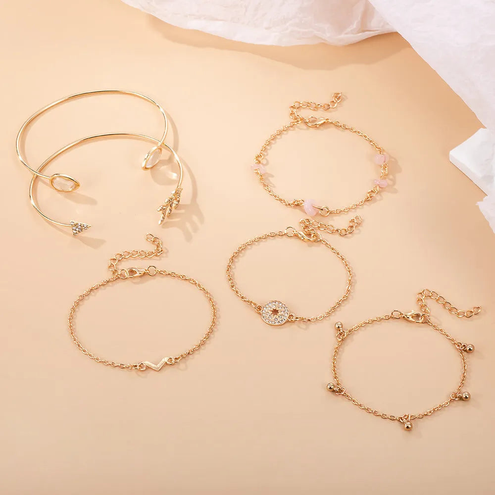 Gold zinc alloy bracelet set with six pieces showing arrow and water drop charms