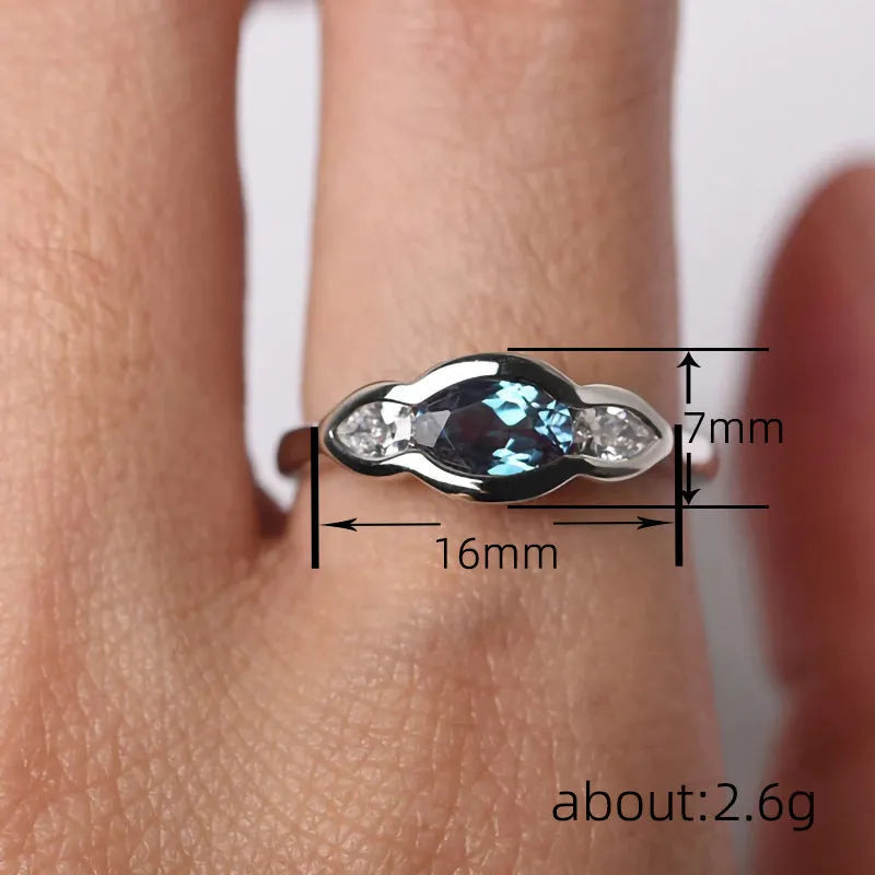Women's geometric ellipse ring with inlaid zircon stone in white gold colour, shown on a hand.