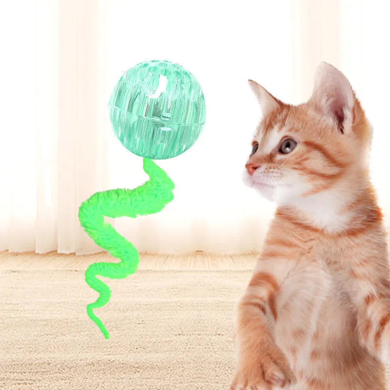 Interactive cat ball toy with elastic worm tail in green colour on wooden floor