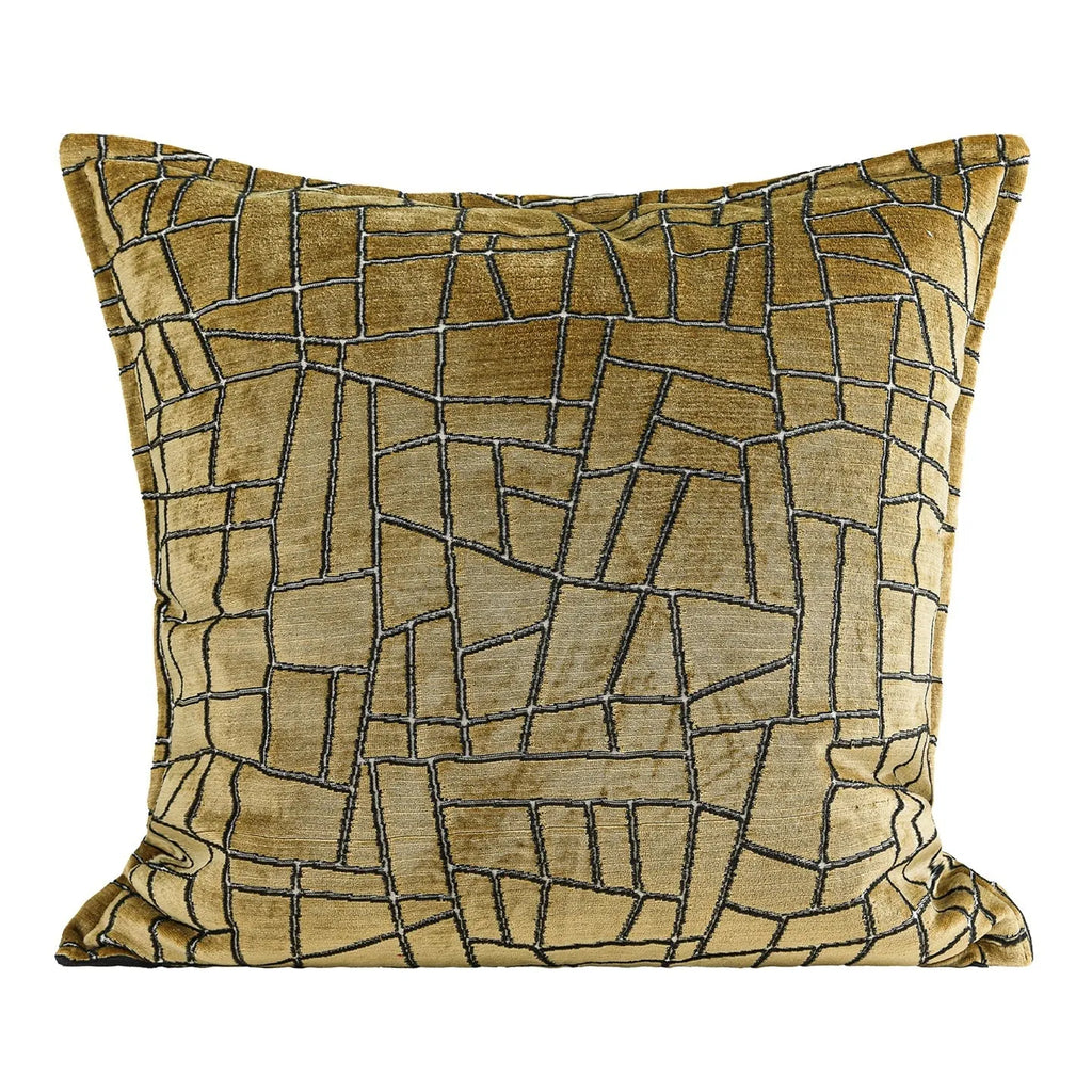 Gold geometric patterned decorative pillow on a grey sofa.