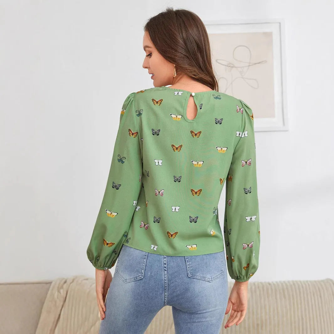 Green women's long sleeve shirt with butterfly print, showing loose fit and button front.