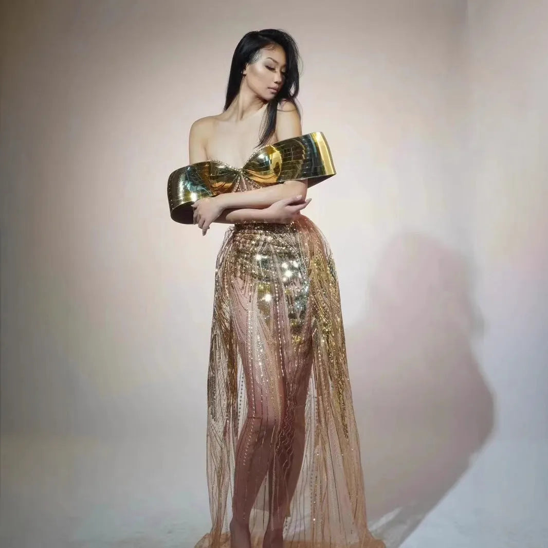 Gold strapless sequin dress with sleeveless tube top and long one-step skirt.