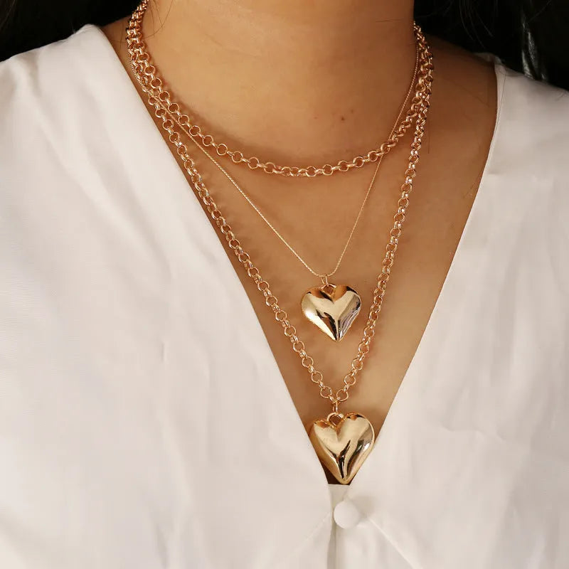 Gold multi-layer heart pendant necklace for women with alloy construction and electroplated finish.