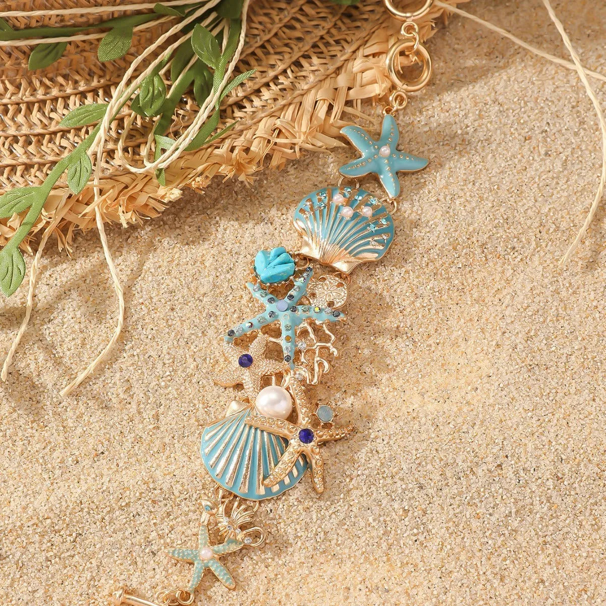Alloy rhinestone bracelet with boat anchor and starfish charm in turquoise, red, or blue.