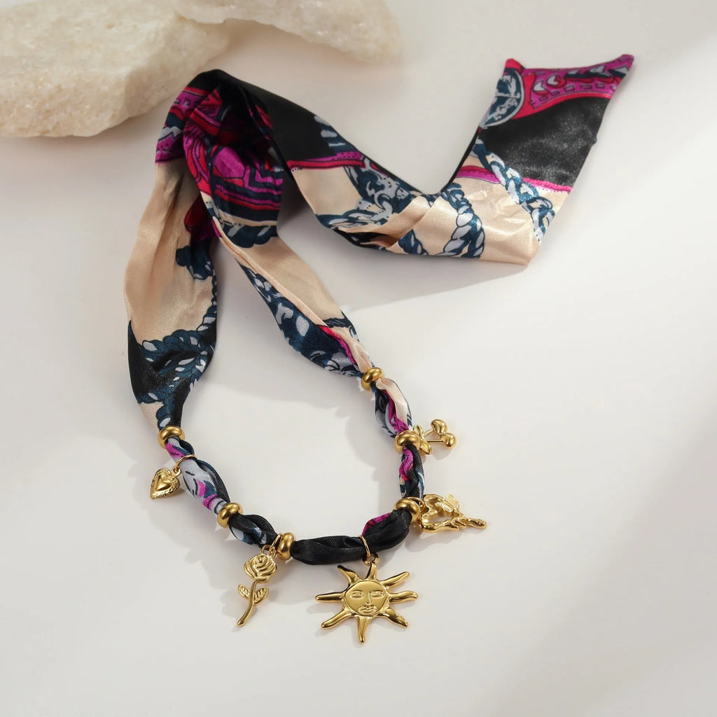 Geometric pendant on a gold chain, shown as a women's necklace or bracelet against an autumn backdrop.