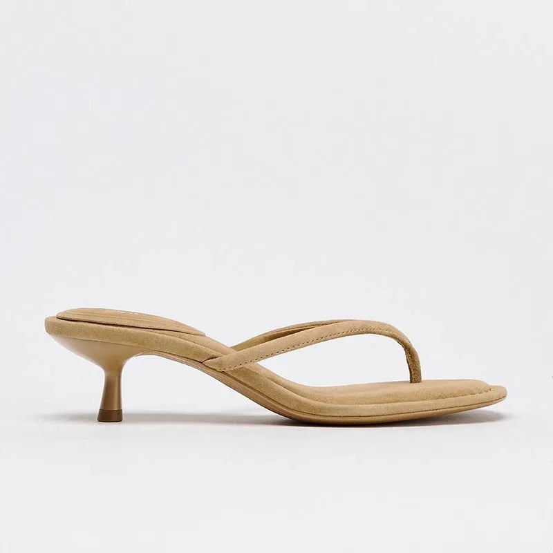 Black women's mid-heel sandals with a round toe and flip-toe strap on a white background