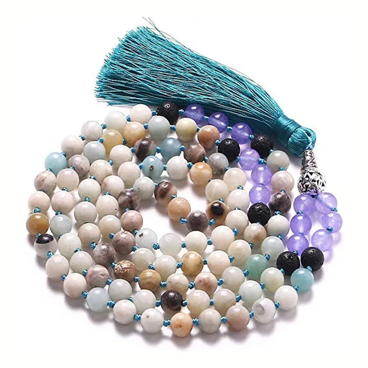 Long beaded agate and amethyst tassel necklace with geometric pendant on a neutral background.