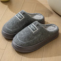 Men's brown suede slippers with thickened sole on wooden floor