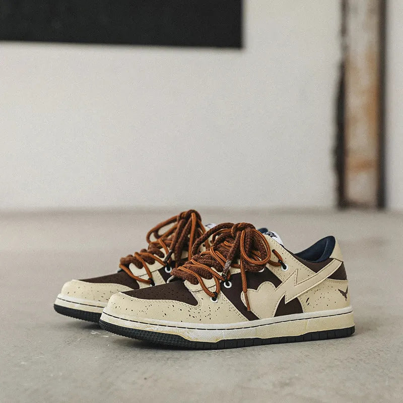 Brown low-top unisex casual sneakers with leather stitching, rubber sole, and front lace-up