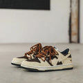 Brown low-top unisex casual sneakers with leather stitching, rubber sole, and front lace-up