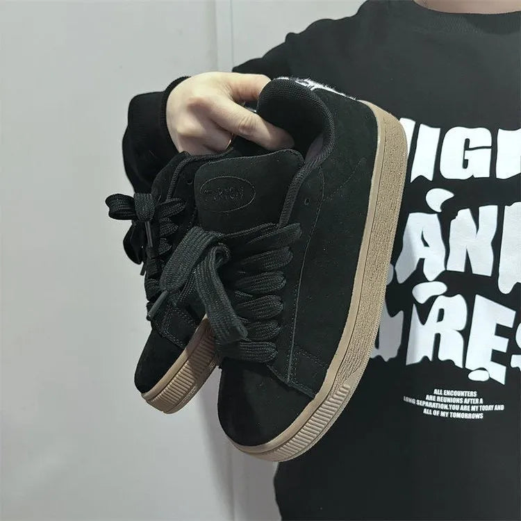 Black retro low-top sneakers with a platform sole and front lace-up closure on a white background.
