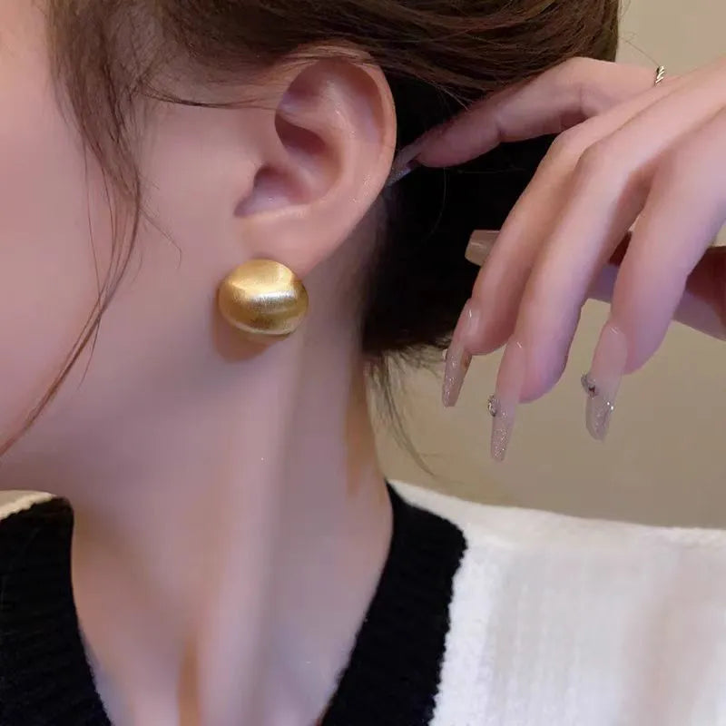 Pair of matte brushed gold bean shaped stud earrings for women with gold and white finish