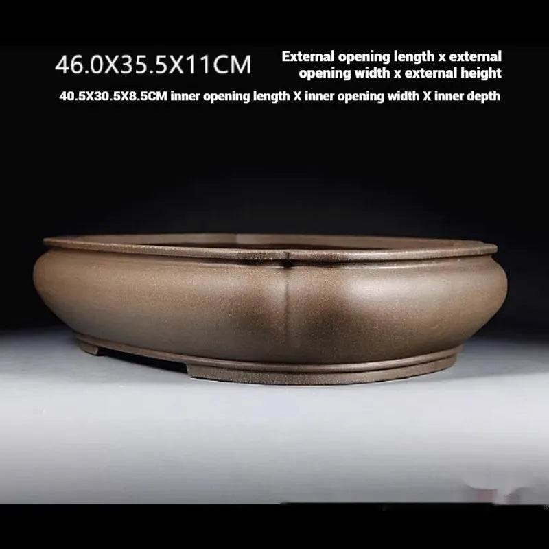 Handmade antique papaya-shaped purple clay flower pot on a tabletop.