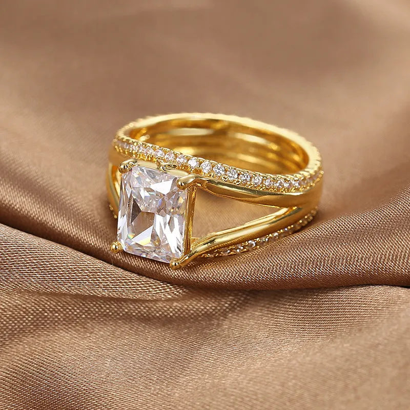 Gold-coloured geometric women's ring with a square zircon stone, shown in sizes 6 to 9.