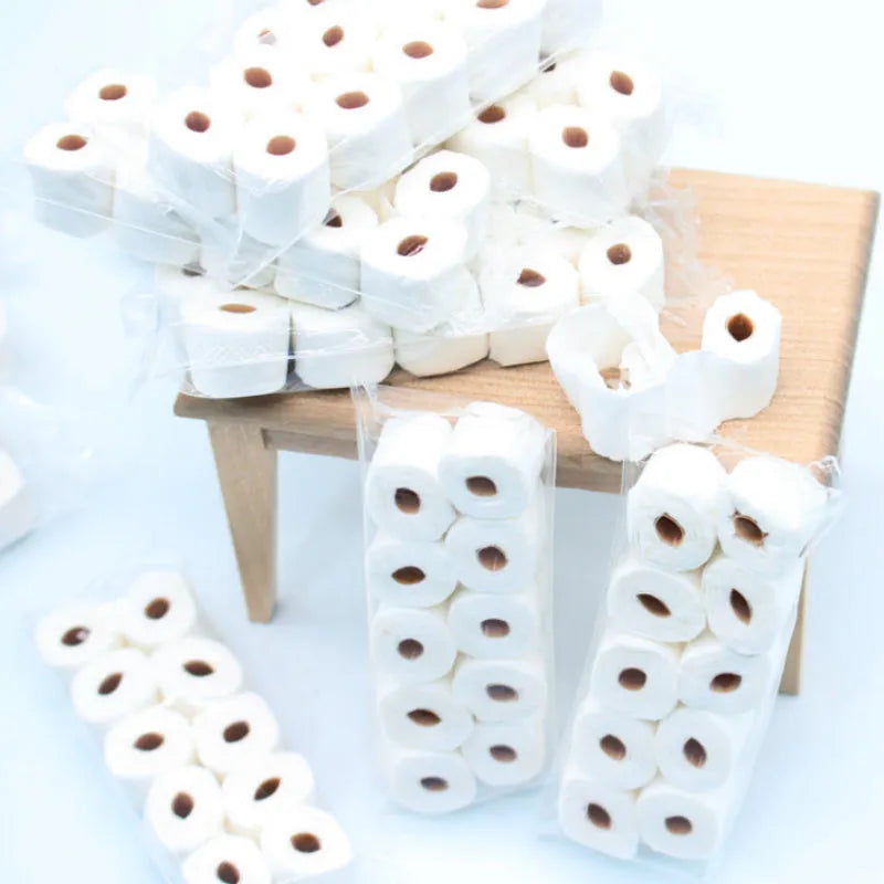 Miniature simulated toilet paper roll model made from paper for dollhouse and children's pretend play.